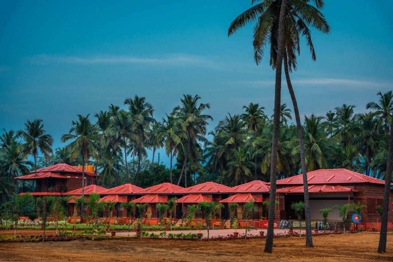 Beach resorts in Murdeshwar — cottages with palm trees